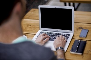 man typing on laptop